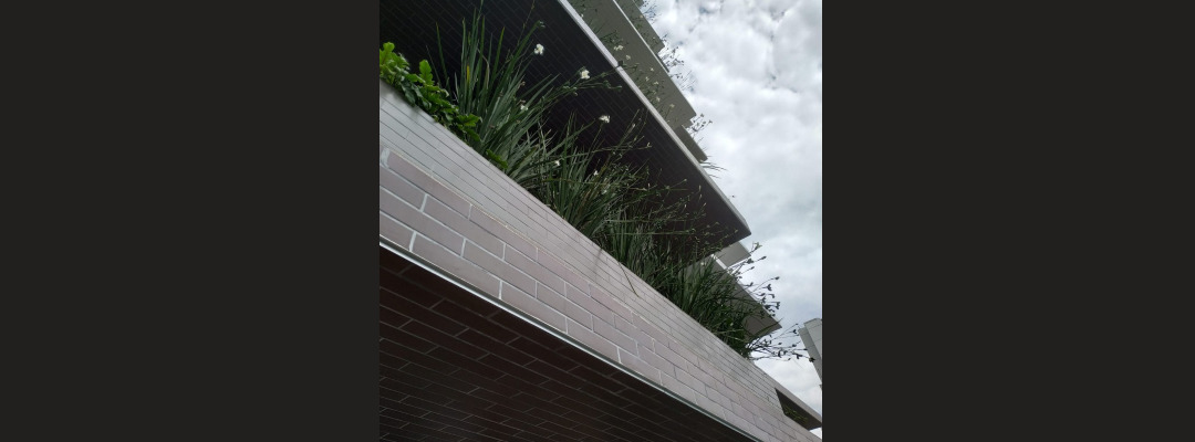 Fachada moderna com floreiras integradas e projeto de paisagismo vertical